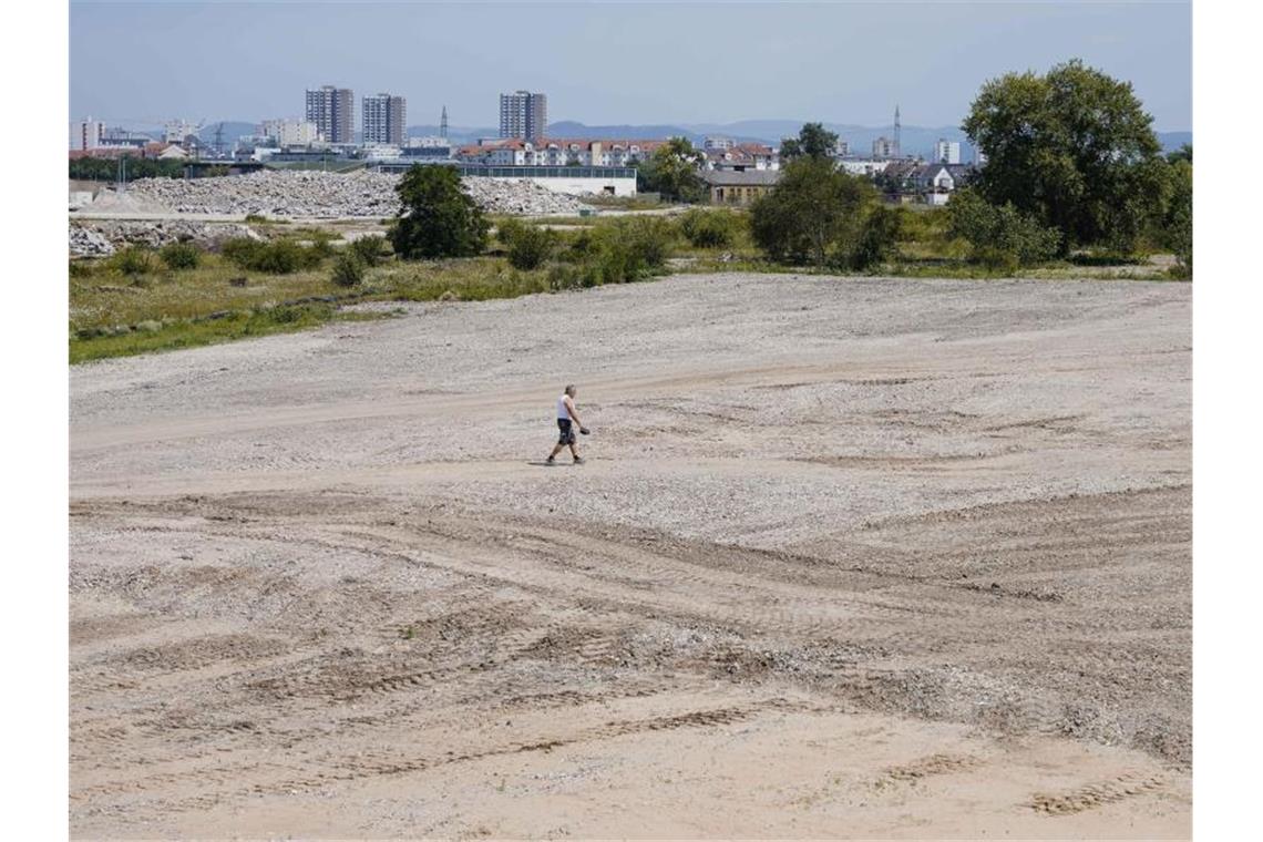 Ein Bauarbeiter geht über eine Baufläche für die Bundesgartenschau 2023. Foto: Uwe Anspach/dpa