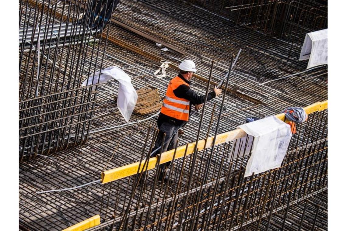 Ein Bauarbeiter steht zwischen den Stahlarmierungen auf einer Baustelle. Foto: Andreas Arnold/dpa/Archivbild