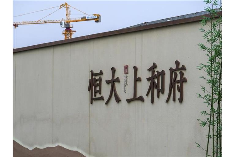 Ein Baukran steht auf einem neuen Wohnbauprojekt von Evergrande in Peking. Foto: Andy Wong/AP/dpa
