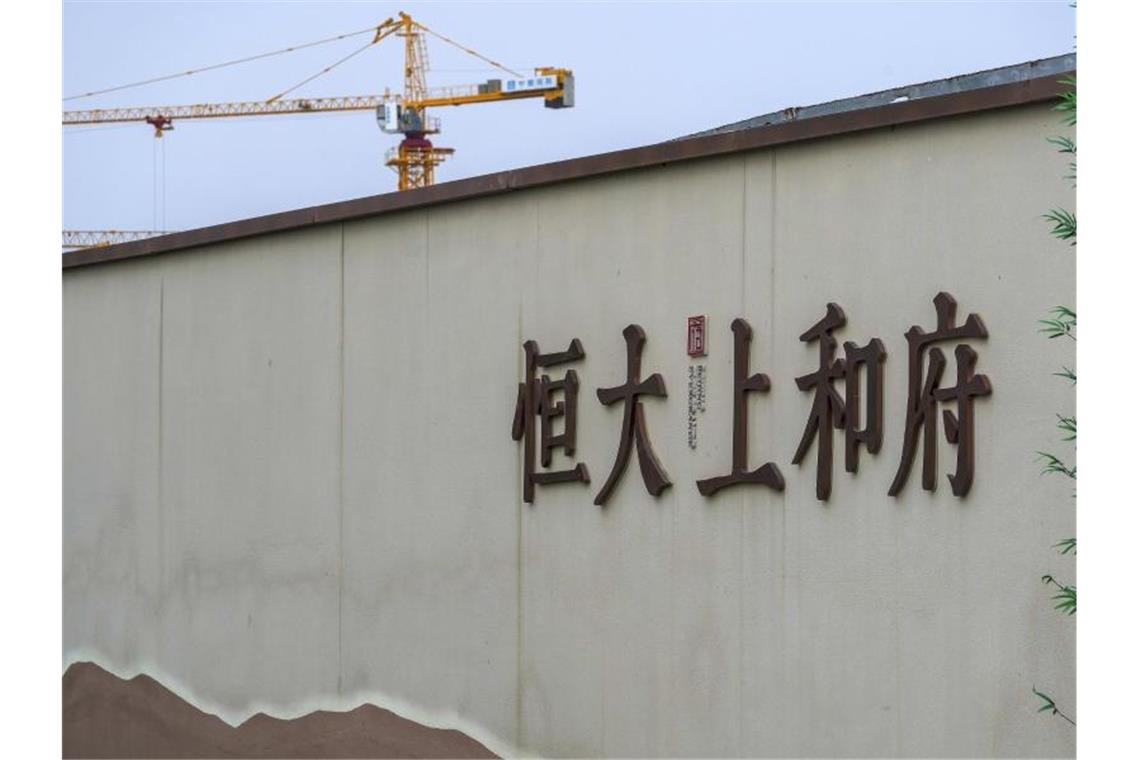 Ein Baukran steht auf einem neuen Wohnbauprojekt von Evergrande in Peking. Foto: Andy Wong/AP/dpa