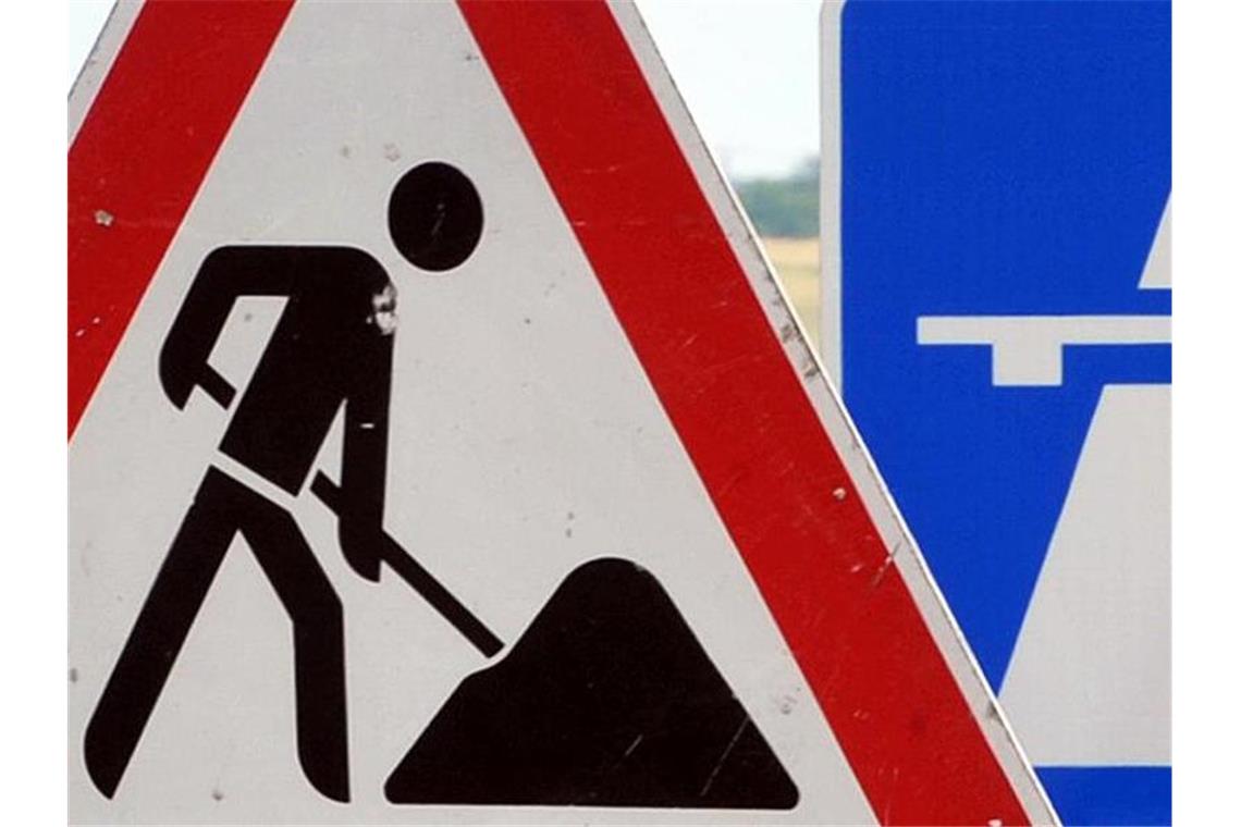 Ein Baustellenschild ist vor einem Autobahnschild platziert. Foto: Martin Schutt/Archivbild