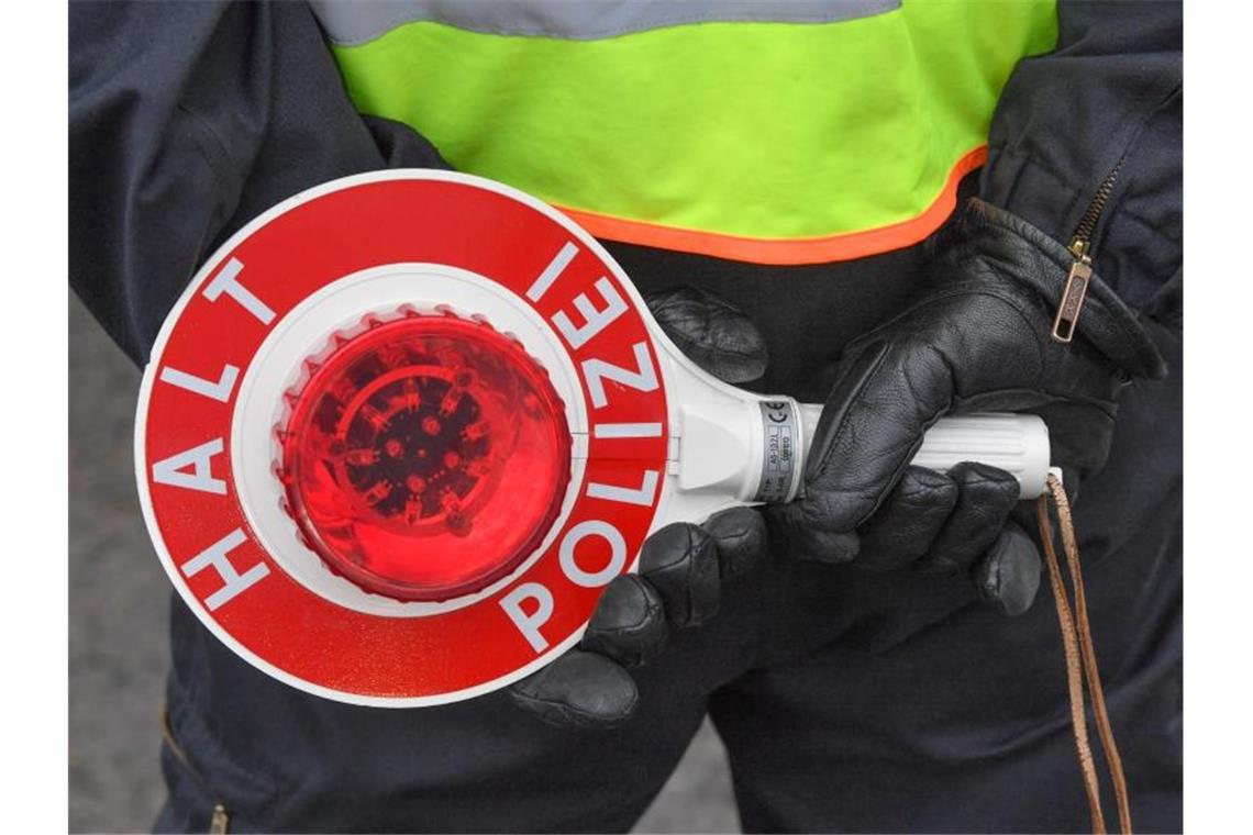 Ein Beamter der Bundespolizei hält eine Kelle in seinen Händen. Foto: Patrick Pleul/zb/dpa/Archiv