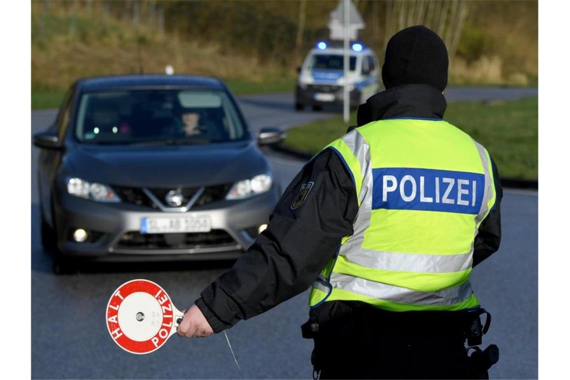 Ein Beamter der Bundespolizei steht an der deutsch-dänischen Grenze an einem Kontrollpunkt. Foto: Carsten Rehder/dpa