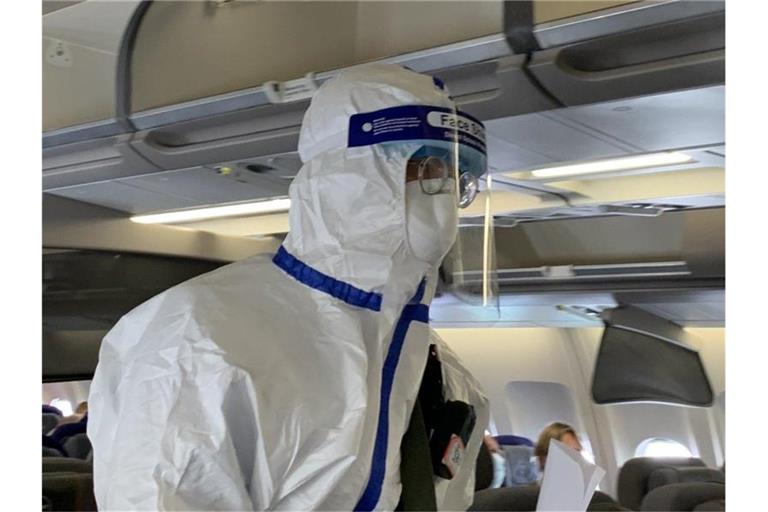 Ein Beamter der chinesischen Gesundheitsbehörde begleitet den Sonderflug, um die Körpertemperatur von Passagieren zu messen und nach Krankheitssymptomen zu fragen. Foto: Andreas Landwehr/dpa