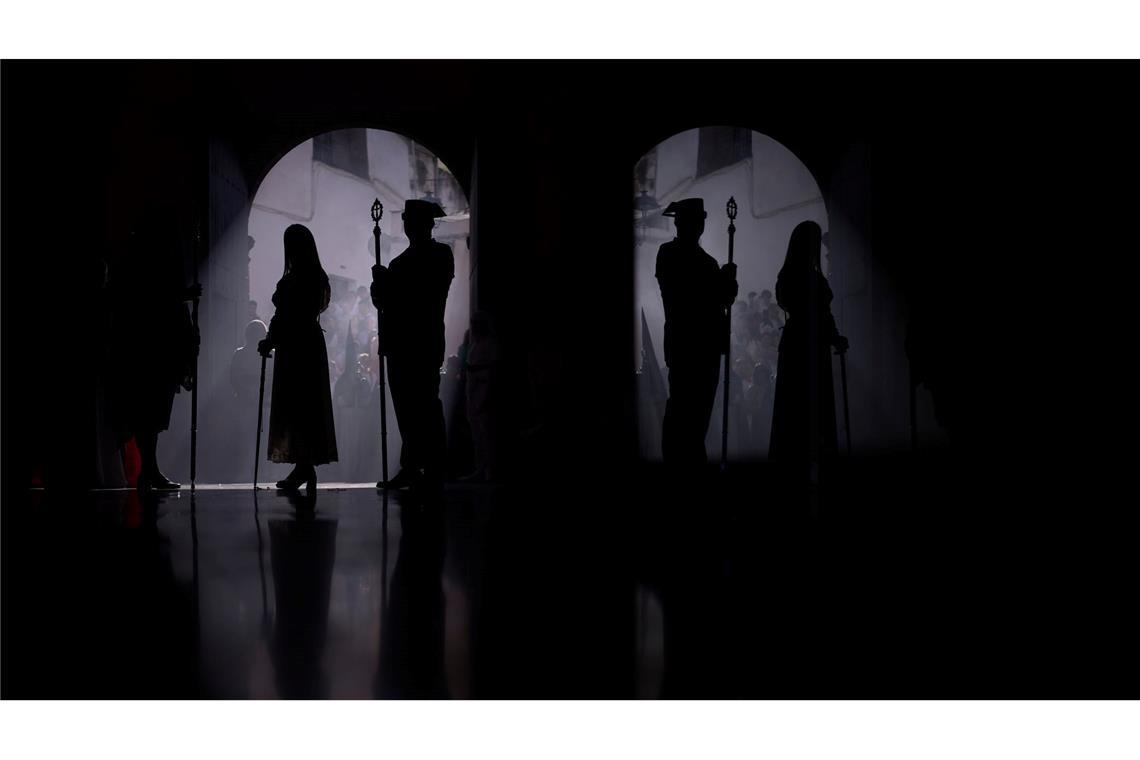 Ein Beamter der Guardia Civil (r) und ein Büßer nehmen an einer Prozession teil.