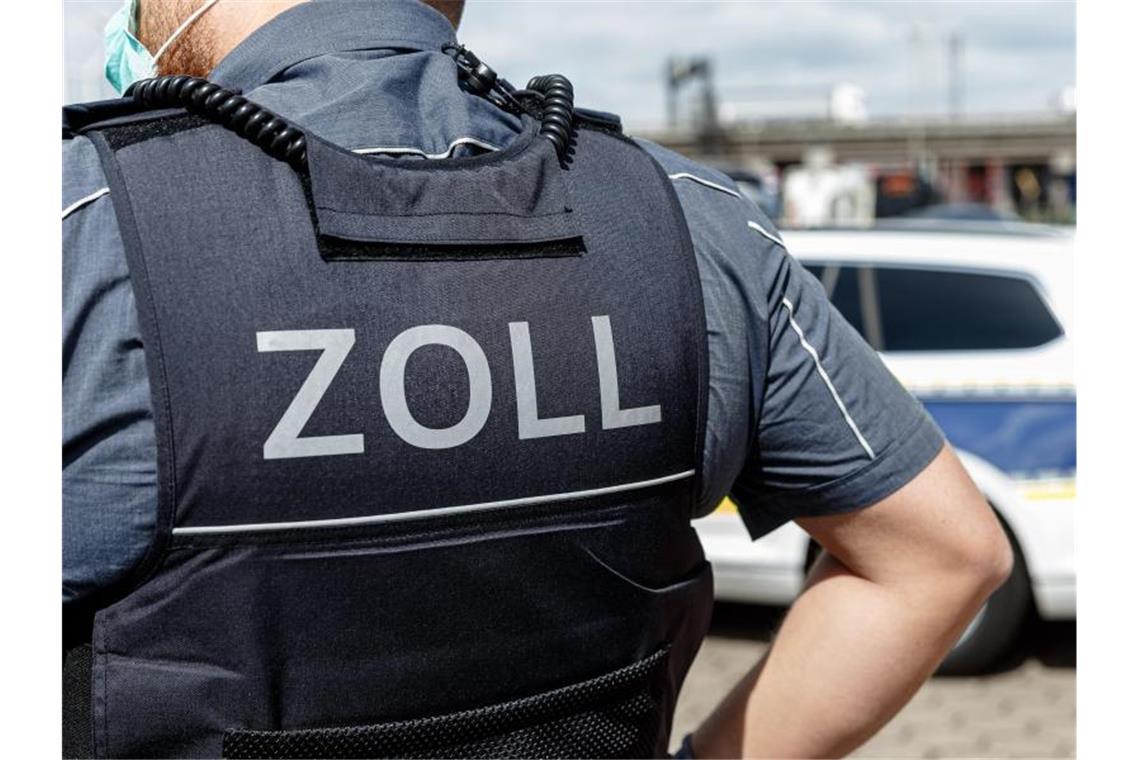 Ein Beamter trägt während seines Dienstes eine Schutzweste mit der Rückenaufschrift "Zoll". Foto: Markus Scholz/dpa/Symbolbild