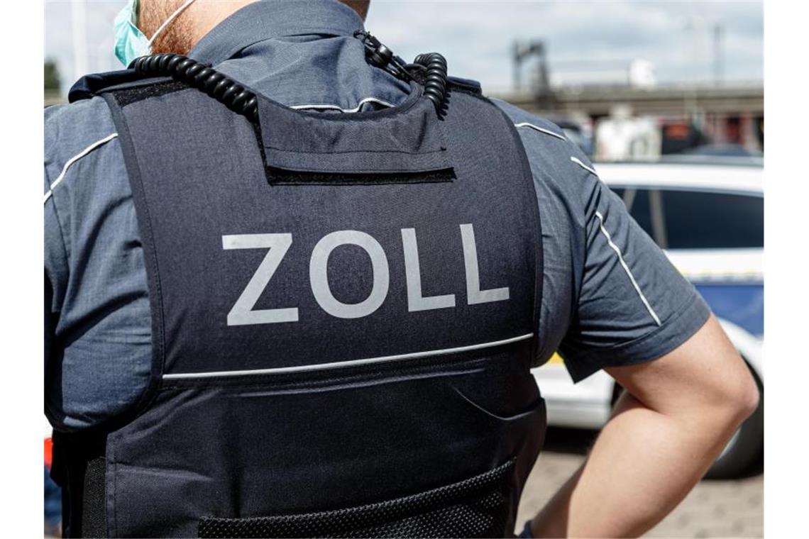 Mann mit 50.000 Euro nach Einreise aus der Schweiz erwischt Ein Beamter trägt während seines Dienstes eine Schutzweste mit der Rückenaufschrift "Zoll". Foto: Markus Scholz/dpa/Symbolbild