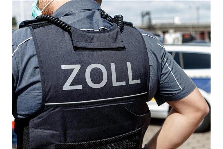 Ein Beamter trägt während seines Dienstes eine Schutzweste mit der Rückenaufschrift "Zoll". Foto: Markus Scholz/dpa/Symbolbild