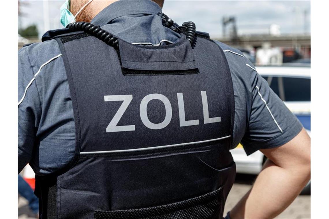 Ein Beamter trägt während seines Dienstes eine Schutzweste mit der Rückenaufschrift "Zoll". Foto: Markus Scholz/dpa/Archiv