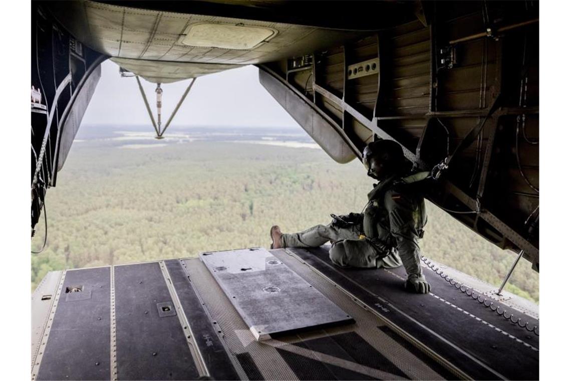 Gewitter ziehen nach Osten - Waldbrand breitet sich aus Ein Besatzungsmitglied der Lufttransportgruppe sitzt bei einem Löschflug der Luftwaffe über dem Waldbrandgebiet bei Jüterbog im CH53 Hubschrauber an der Heckklappe. Foto: Christoph Soeder