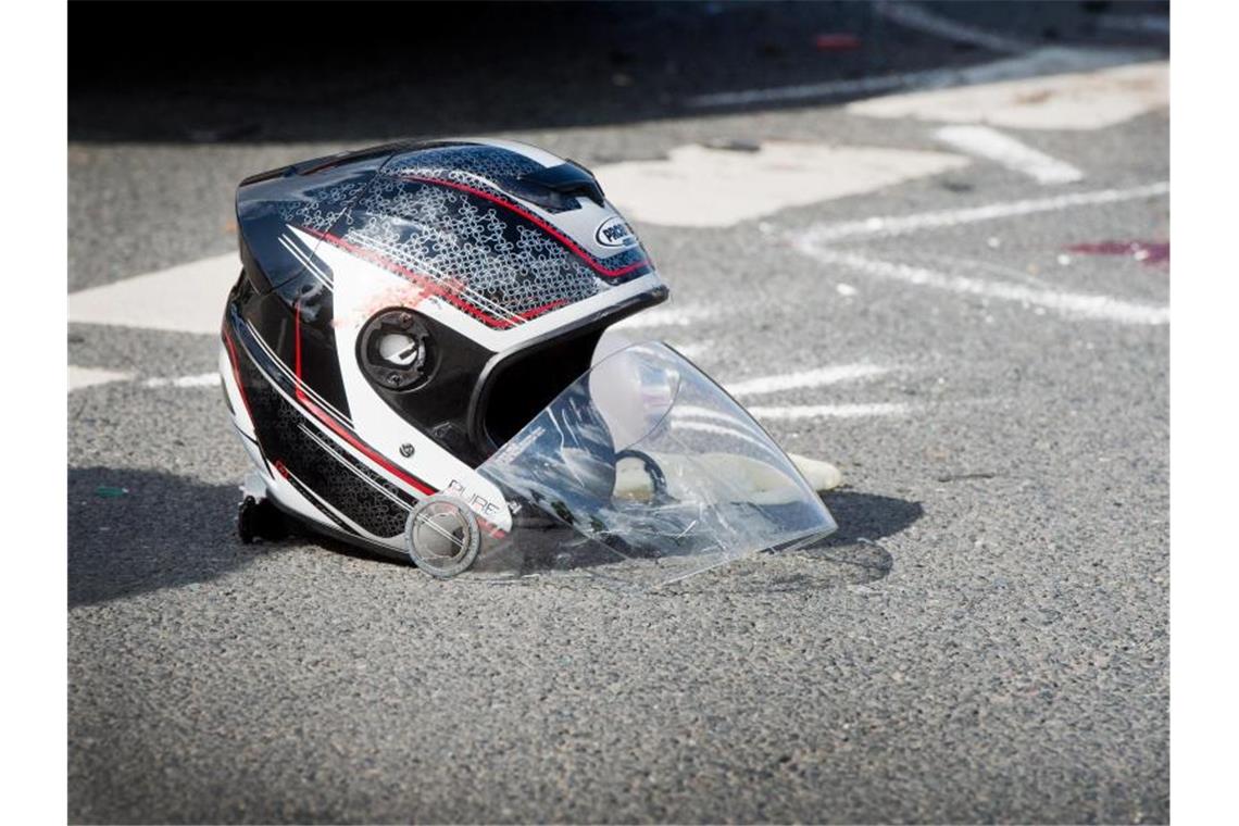 Ein beschädigter Motorradhelm liegt nach dem Unfall auf dem Boden. Foto: Julian Stratenschulte/dpa/Symbolbild