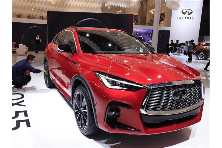 Ein Besucher begutachtet den Infiniti QX55 auf der internationalen Automesse „Auto Shanghai 2021“. Foto: Ng Han Guan/AP/dpa