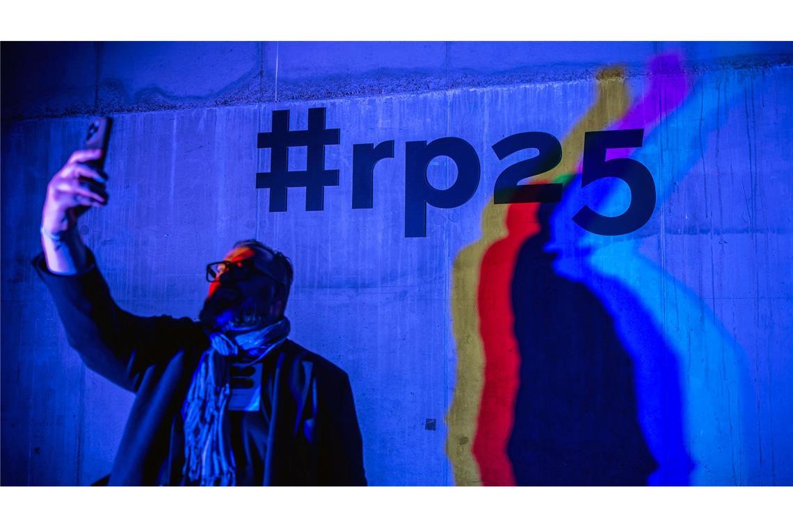 Ein Besucher der Medienkonferenz Re:publica macht ein Selfie vor dem Hashtag "#rp25".