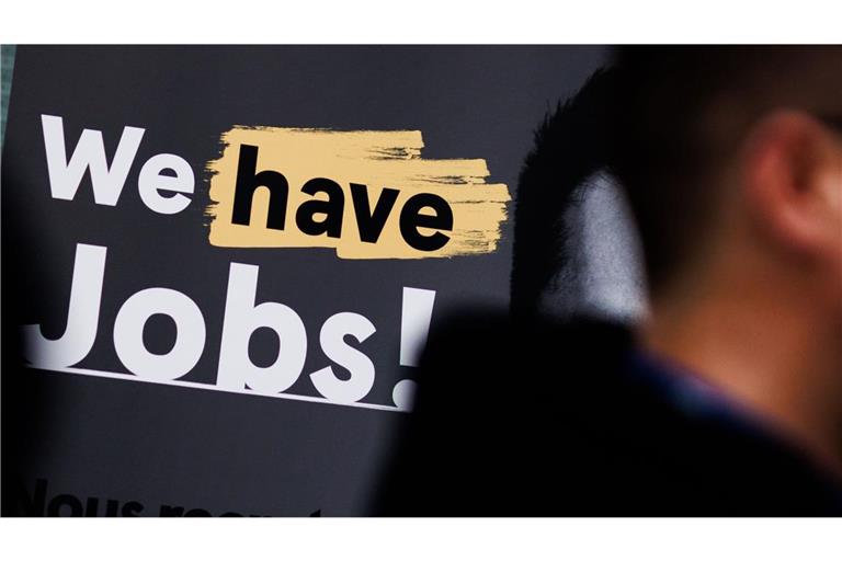 Ein Besucher geht am 17. April 2024 an einem Stand mit dem Schriftzug „We have Jobs!“ bei der Jobmesse für Geflüchtete „FuTog Berlin“ im Ludwig Erhard Haus vorbei.