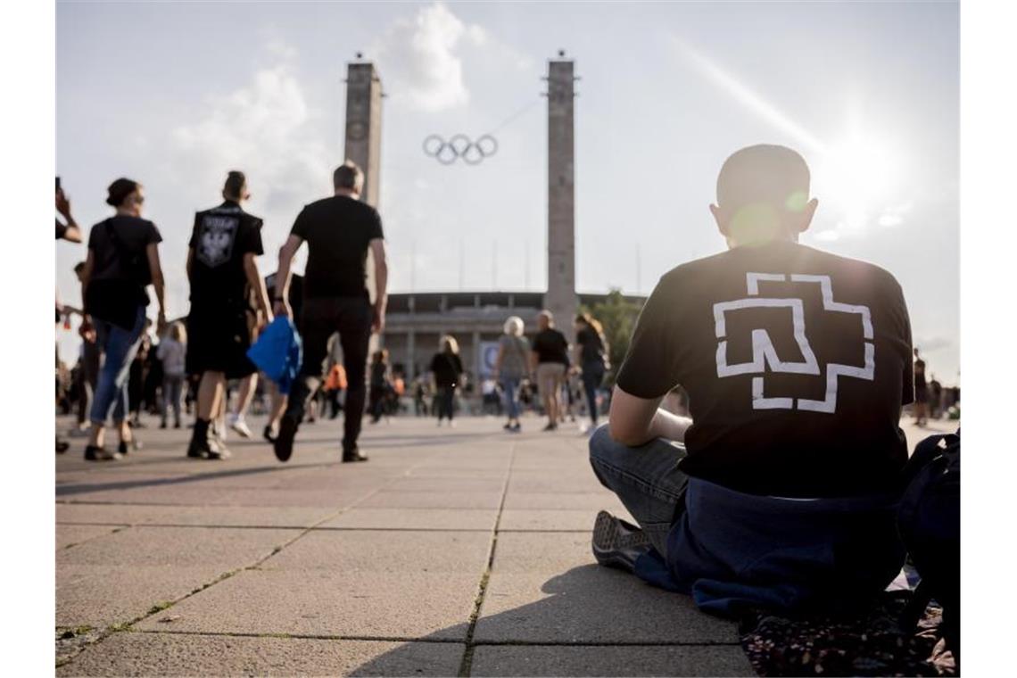Ein Besucher sitzt vor Beginn des Konzerts der Band Rammstein vor dem Berliner Olympiastadion. Foto: Christoph Soeder/Archivbild