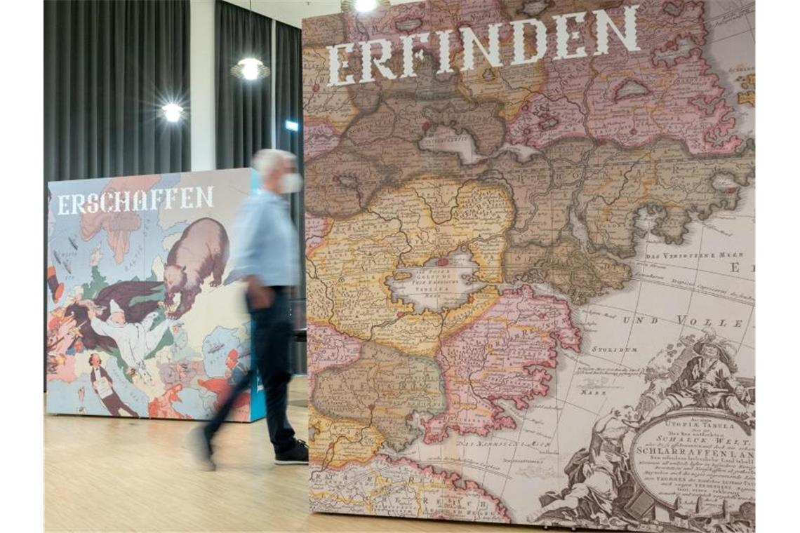 Ein Betrachter läuft durch die Ausstellung von Landkarten mit dem Titel „Fantastische Welten“. Foto: Bernd Weißbrod/dpa