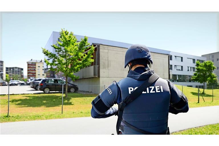 Ein bewaffneter Polizist steht in der Nähe des Tatorts.