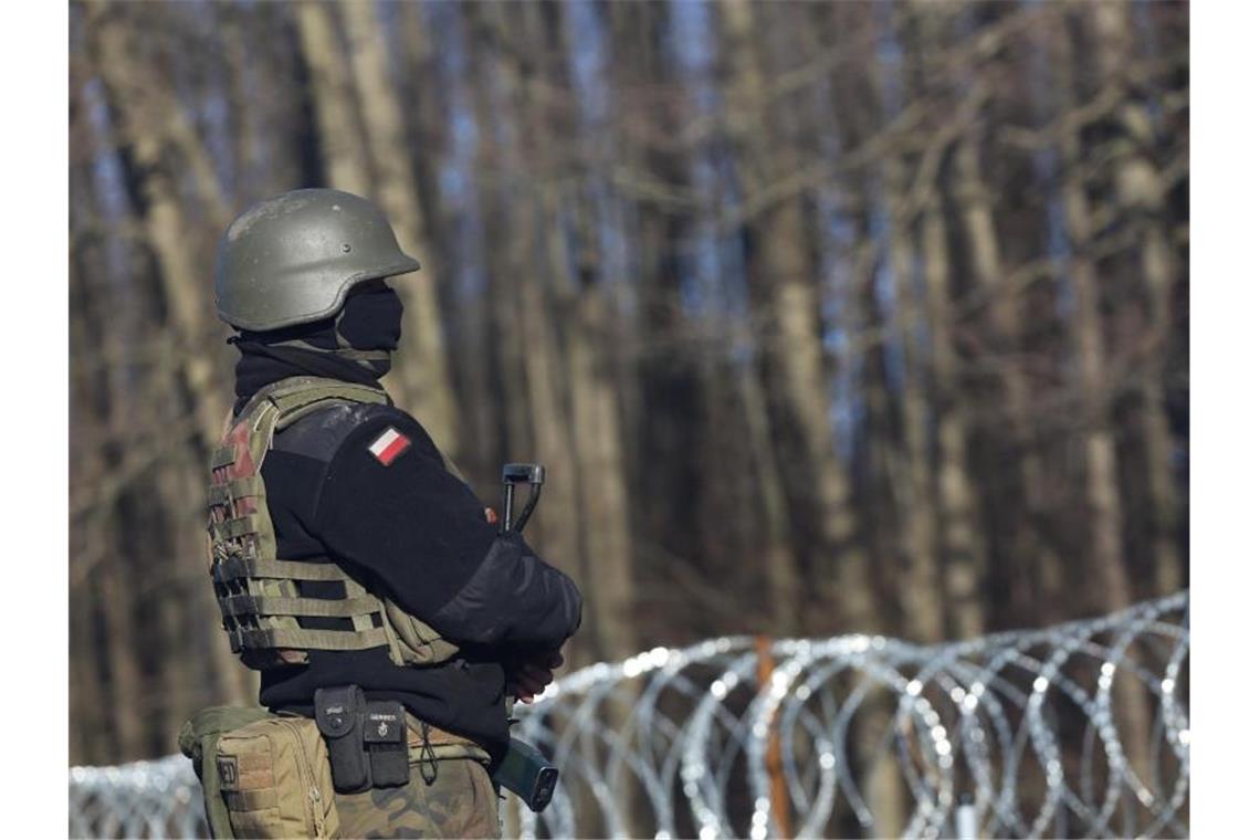 Ein bewaffneter polnischer Soldat bewacht in der Nähe des Ortes Usnarz Gorny die EU-Außengrenze zu Belarus. Foto: Doris Heimann/dpa