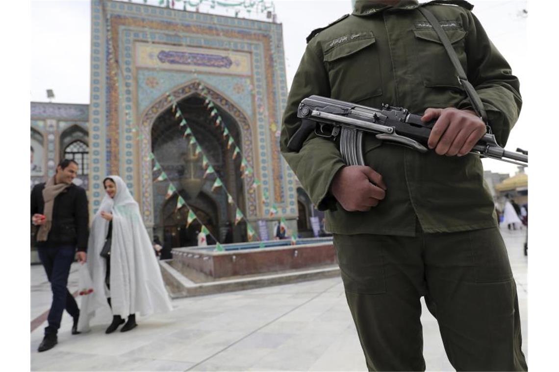 Ein bewaffneter Soldat steht vor einem Wahllokal in Teeheran. Foto: Ebrahim Noroozi/AP/dpa