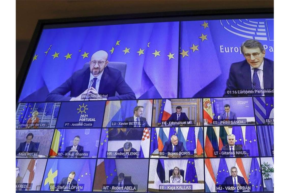 EU arbeitet am Corona-Pass für freies Reisen Ein Bildschirm zeigt Charles Michel (l, oben), Präsident des Europäischen Rates, der per Video an einem EU-Sondergipfel teilnimmt. Foto: Olivier Hoslet/Pool EPA/AP/dpa