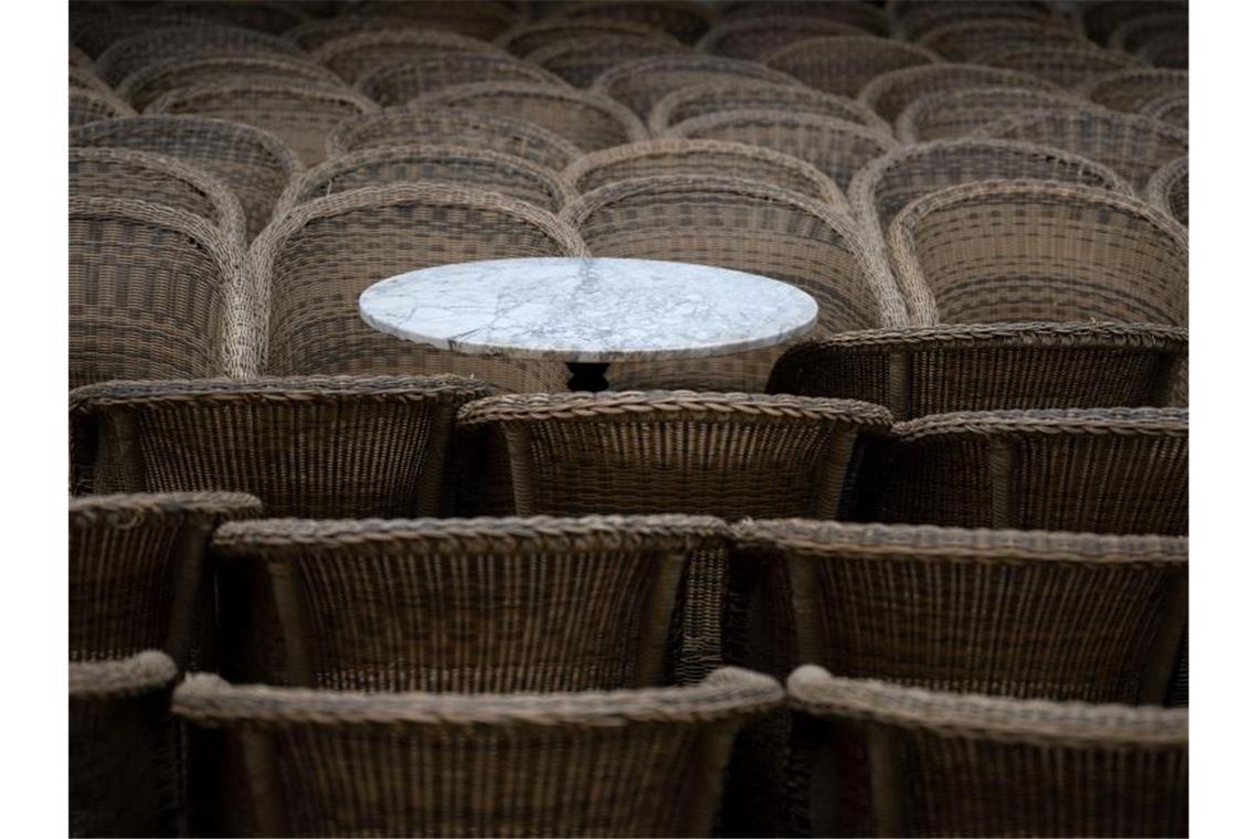 Ein Bistrotisch steht im Außenbereich eines gastronomischen Betriebs zwischen Stühlen. Foto: Marijan Murat/dpa/Symbolbild