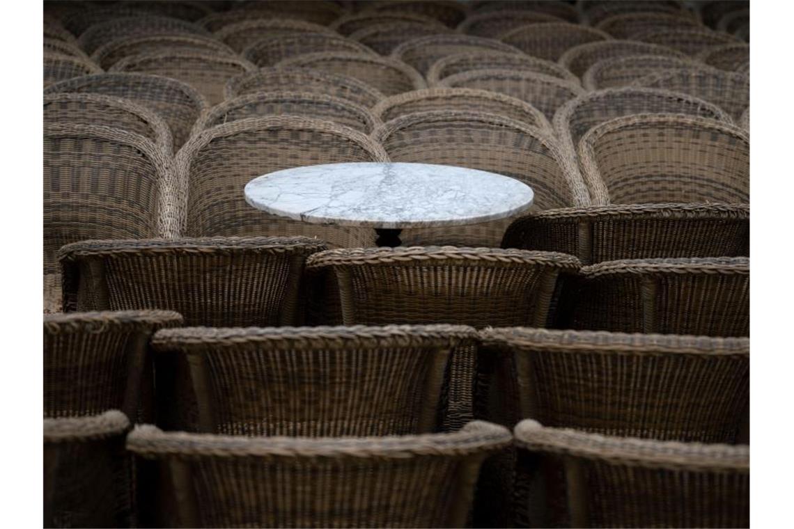 Ein Bistrotisch steht zwischen Stühlen:. Foto: Marijan Murat/dpa/Archivbild