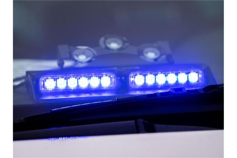 Ein Blaulicht leuchtet unter der Frontscheibe eines Einsatzfahrzeugs der Polizei. Foto: Lino Mirgeler/dpa/Symbolbild