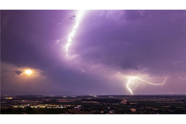 Ein Blitz geht am 28. Juni über dem Rheintal nieder während im Vordergrund der Kaiserstuhl zu sehen ist. Nach einer Woche mit Rekordhitze entladen sich zahlreiche Gewitter über dem Süden Baden-Württembergs und dem Dreiländereck.