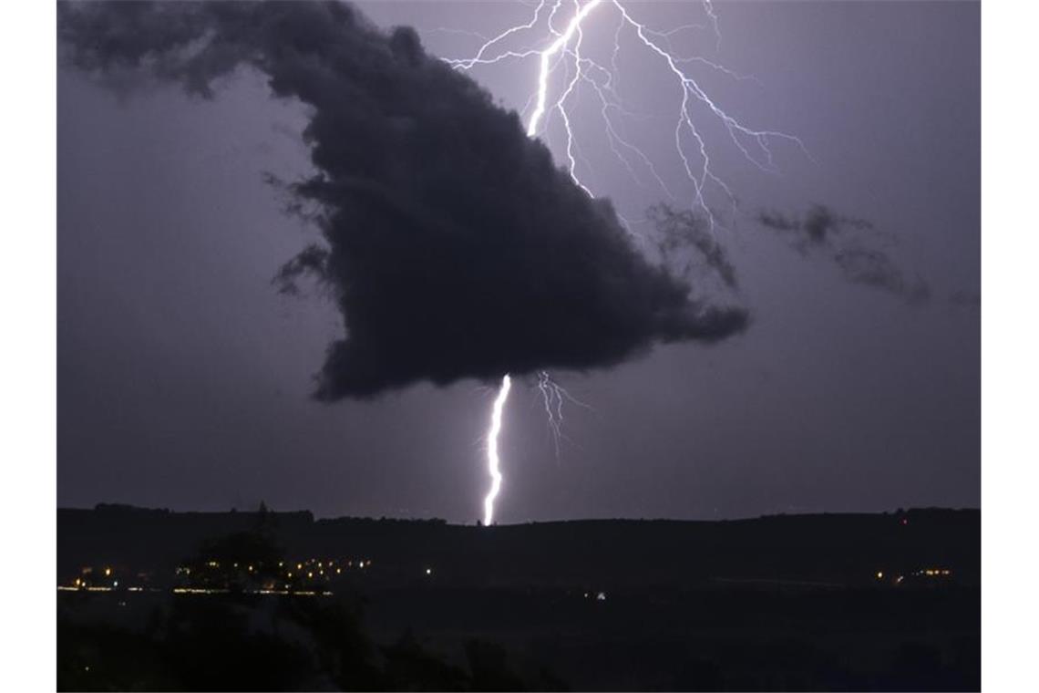 Gewitter: Umgestürzte Bäume und überflutete Straßen Ein Blitz schlägt bei einem Gewitter in den Boden ein. Foto: Patrick Seeger/Archivbild