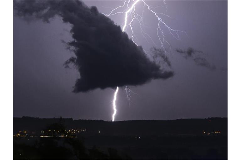Ein Blitz schlägt bei einem Gewitter in den Boden ein. Foto: Patrick Seeger/Archivbild