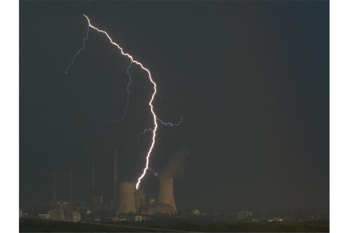 Ein Blitz zuckt hinter dem Kraftwerk Staudinger. Foto: Sebastian Gollnow/dpa