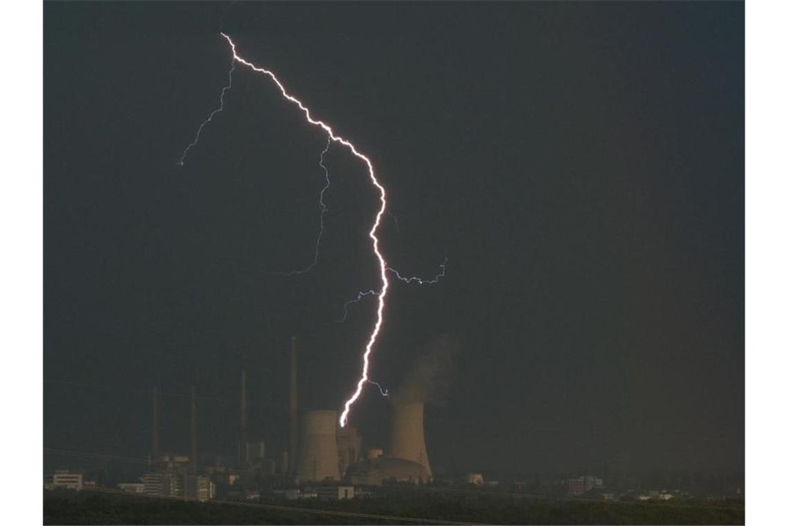 Ein Blitz zuckt hinter dem Kraftwerk Staudinger in Hanau. Foto: Sebastian Gollnow/dpa