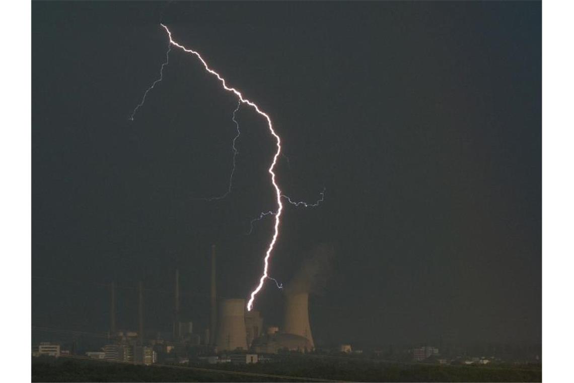 Heftige Unwetter in Bayern und Hessen Ein Blitz zuckt hinter dem Kraftwerk Staudinger in Hanau. Foto: Sebastian Gollnow/dpa