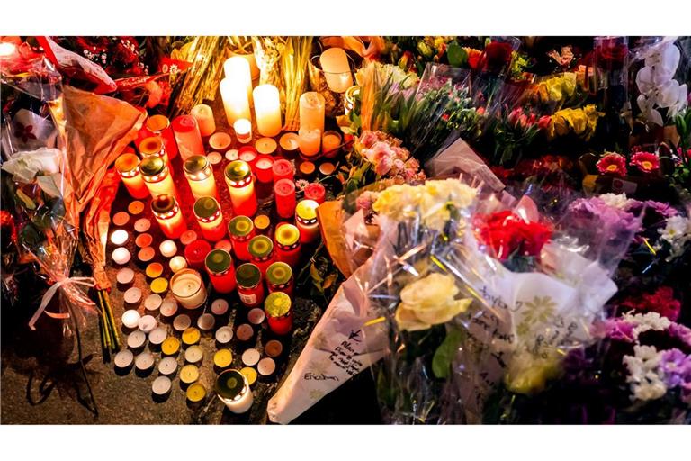 Ein Blumen- und Kerzenmeer erinnert an Tote und Verletzte in der Nähe des Brandortes.