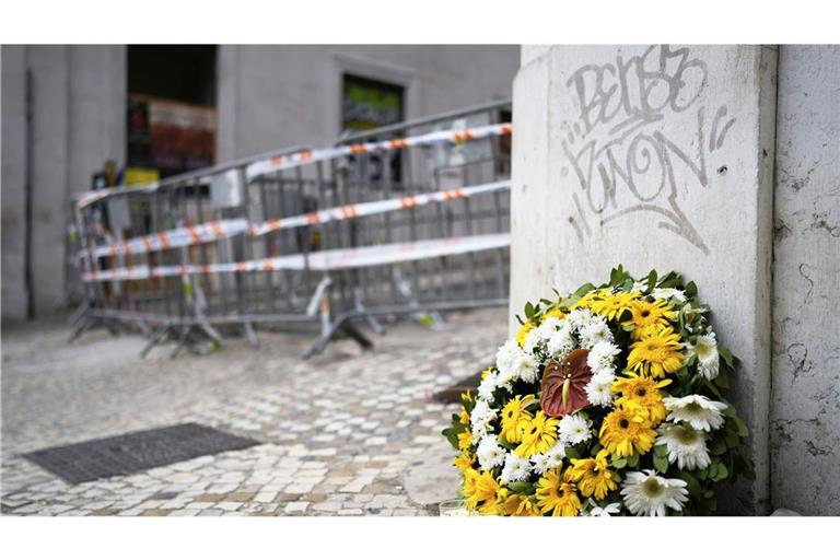 Ein Blumenkranz steht am Unfallort einer entgleisten und verunglückten Standseilbahn.