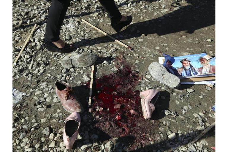 Ein Blutfleck und Schuhe nach einem tödlichen Angriff. Mehr als 100.000 Menschen sind seit Jahresbeginn in Afghanistan vor Kämpfen und Gefechten aus ihren Dörfern und Städten geflohen. Foto: Rahmat Gul/AP/dpa