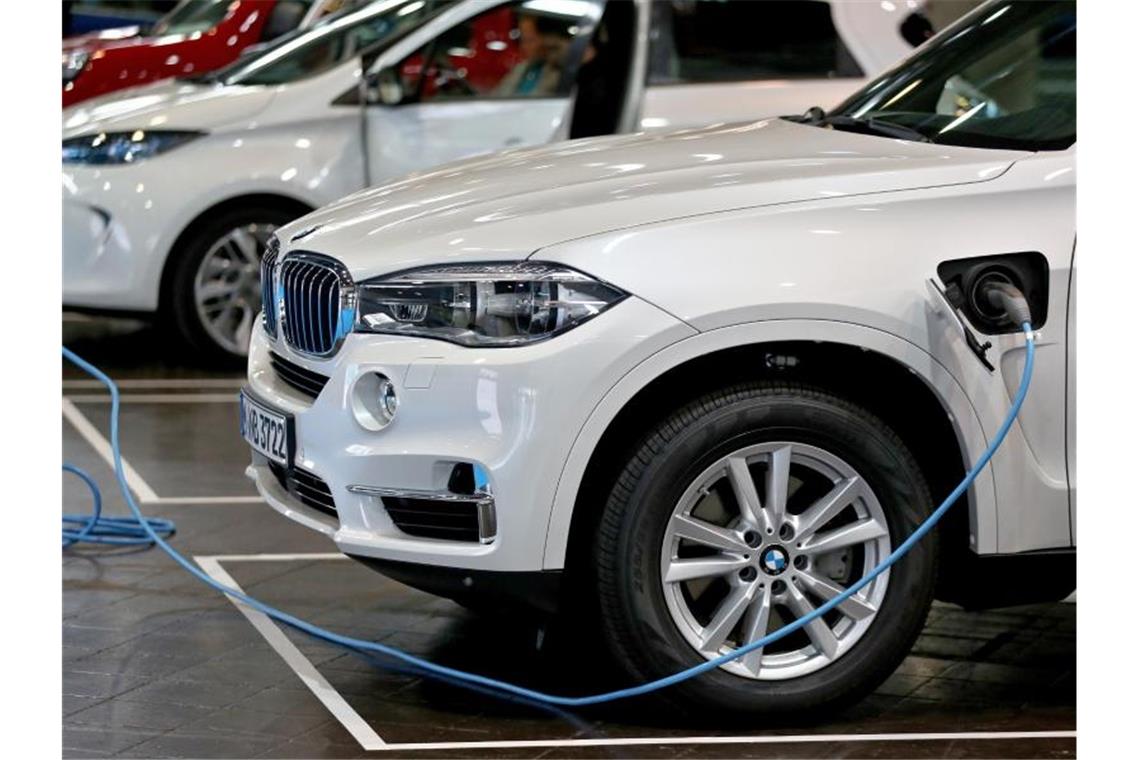 Ein BMW-SUV als Plug-in-Hybrid wird geladen. Foto: Jan Woitas/dpa-Zentralbild/dpa