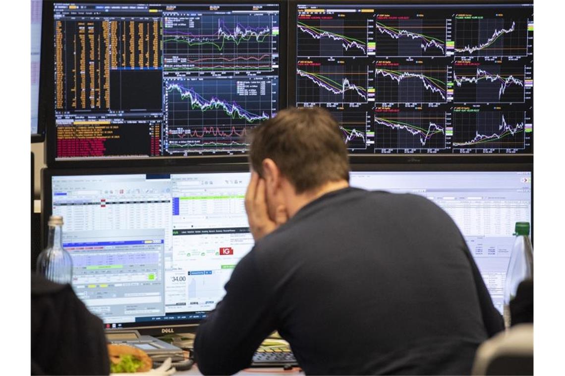 Experte erwartet 60 bis 70 Prozent Infizierte in Deutschland Ein Börsenhändler an der Frankfurter Börse blickt auf seine Monitore. Der Dax ist am Morgen um mehr als 5 Prozent gefallen. Foto: Boris Roessler/dpa