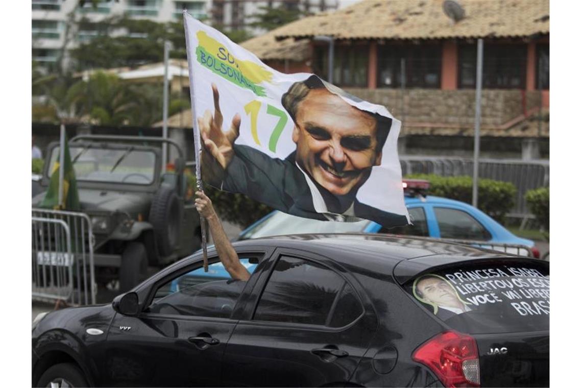 Ein Bolsonaro-Anhänger fährt im Oktober 2018 mit einem Bild des damals neuen Präsidenten an dessen Residenz vorbei. Foto: Leo Correa/AP