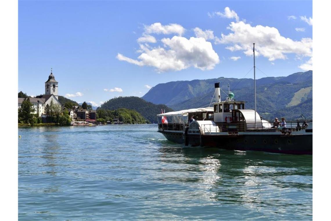 Ein Boot fährt über den Wolfgangsee. In der kleinen Gemeinde sind in den vergangenen Tagen mehr als 60 Corona-Tests positiv ausgefallen. Foto: Kerstin Joensson/AP/dpa