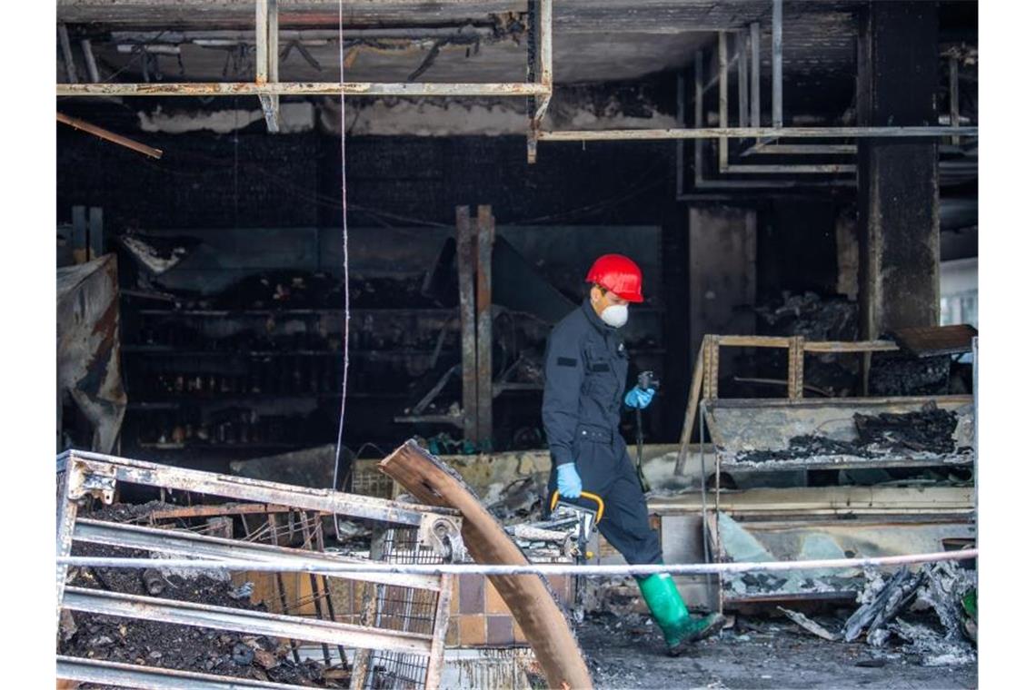 Ein Brandermittler der Polizei sucht im April 2020 nach dem Brand in einem türkischen Geschäft nach Spuren. Foto: Lino Mirgeler/dpa/Archiv