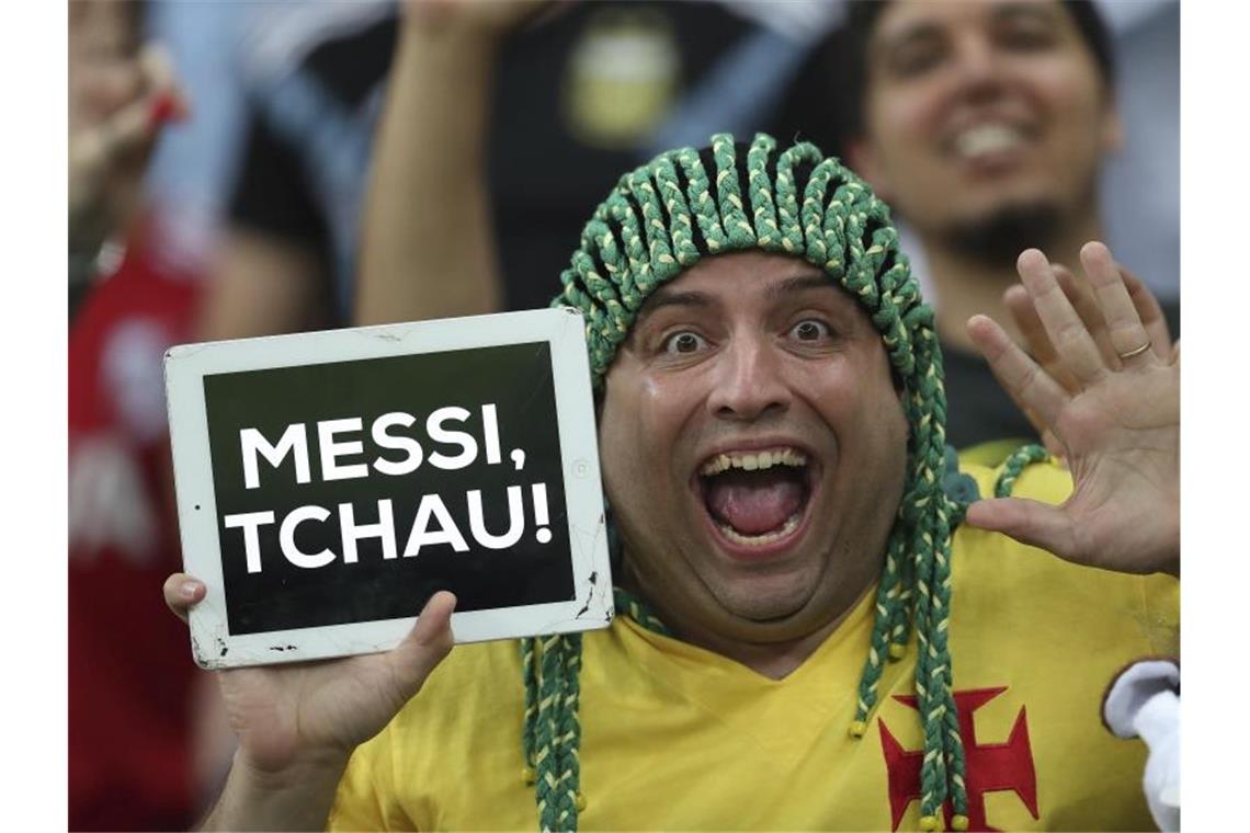 Ein brasilianischer Fan zeigt nach dem Spiel ein Schild mit der Ausfschrift „Messi, Tschau“. Foto: Natacha Pisarenko/AP