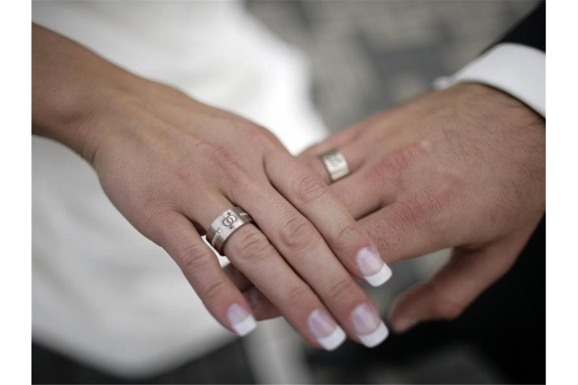 Ein Brautpaar legt nach dem Ringtausch die Hände übereinander. Foto: Jörg Carstensen/dpa/Symbolbild