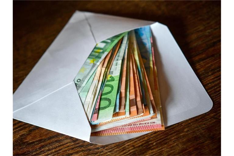 Ein Briefumschlag mit Eurobanknoten. Foto: Patrick Pleul/zb/dpa/Symbolbild
