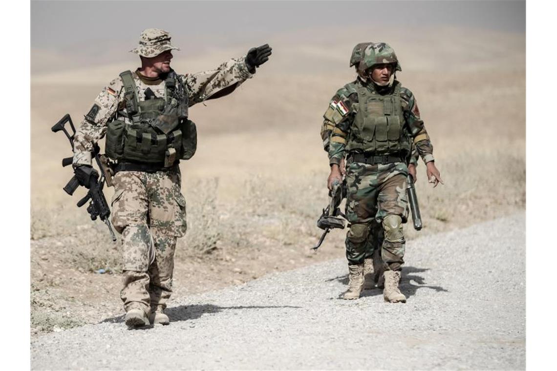 Ein Bundeswehrsoldat und Kämpfer der kurdischen Peshmerga während der Ausbildung nahe Erbil im Norden des Irak. Foto: Michael Kappeler/dpa