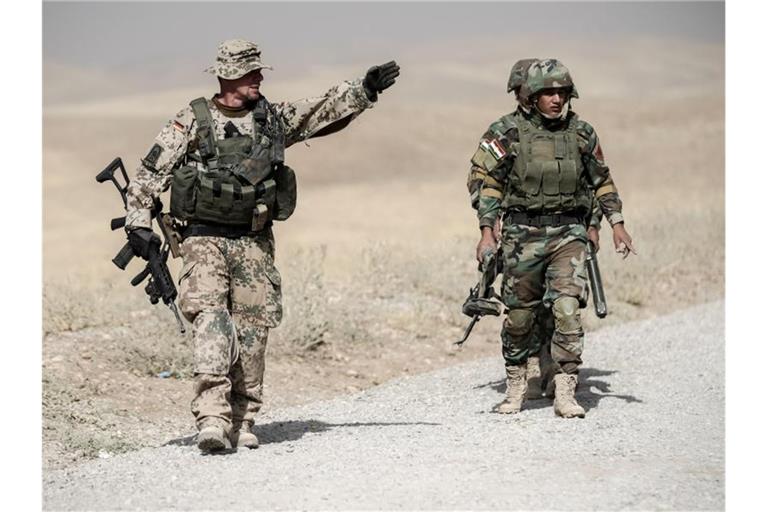 Ein Bundeswehrsoldat und kurdische Peshmerga im irakischen Erbil. Foto: Michael Kappeler/Archiv