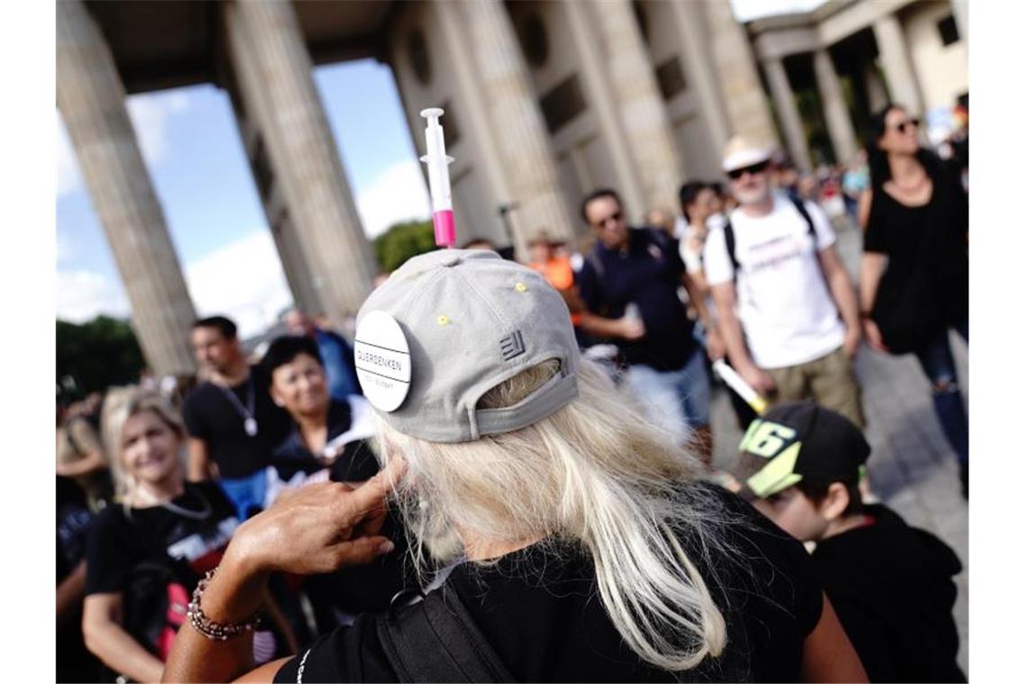 Ein Button „Querdenken 711 Stuttgart“ ist an der Kappe eines Demonstranten zu sehen. Foto: Kay Nietfeld/dpa