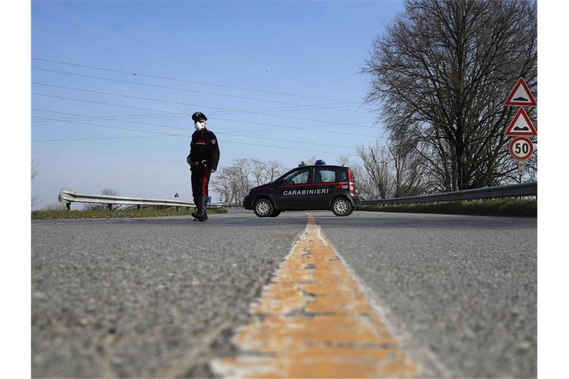 Ein Carabinieri kontrolliert den Grenzbereich des abgesperrten Gebietes um die unter Quarantäne stehende Stadt Codogno. Foto: Antonio Calanni/AP/dpa