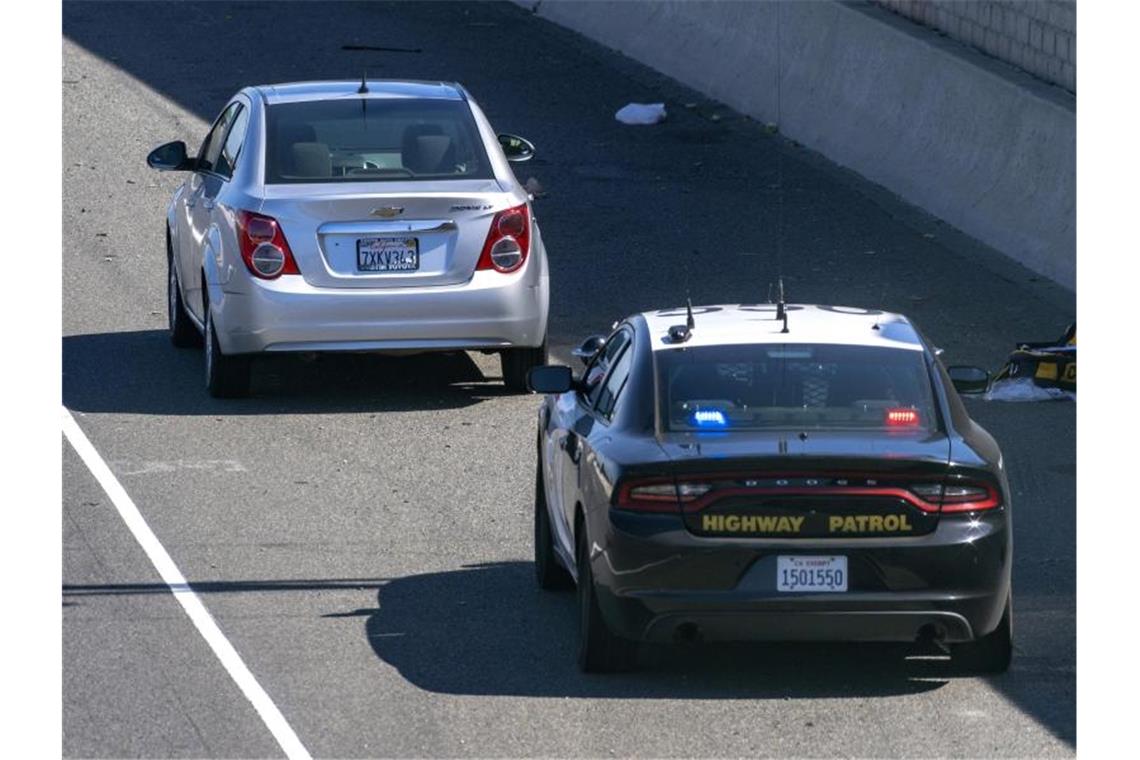 Ein Chevrolet Sonic (l.) am 21. Mai auf dem Seitenstreifen des Freeway 55 in Orange, nachdem Schüsse gefallen waren. Foto: Mark Rightmire/The Orange County Register/dpa