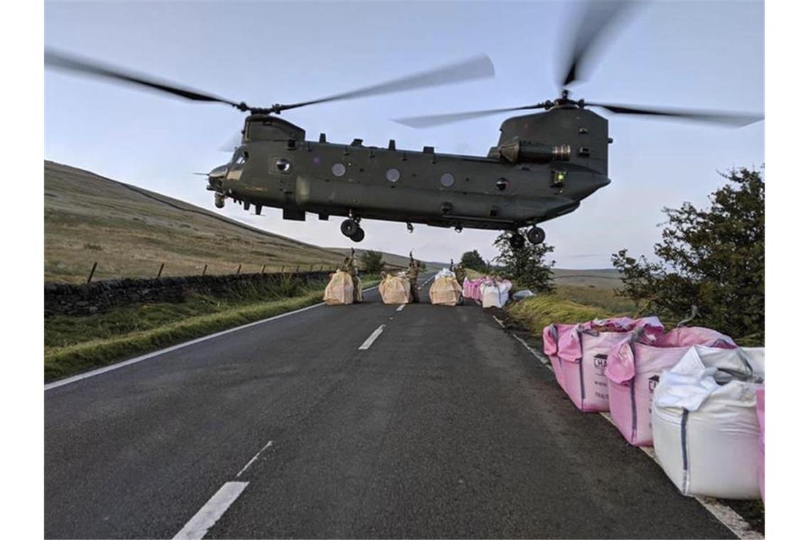 Weiter Angst vor Dammbruch in Nordengland Ein „Chinook“-Lasten-Hubschrauber ist im Einsatz, um mit Sand-Kies-Säcken die Mauer des Reservoirs zu stabilisieren und an anderer Stelle Wasserläufe umzuleiten. Foto: Raf Benson/MOD/AP